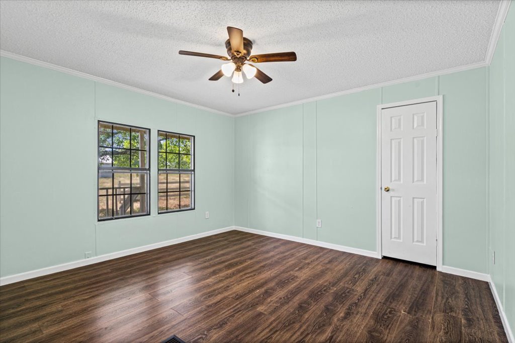 13501 Nutty Brown Road, Unit B Austin, TX 78737 - Photo 19 of 29 Laminated wood-style flooring extends through this tranquil room, illuminated by a multi-bladed ceiling fan.