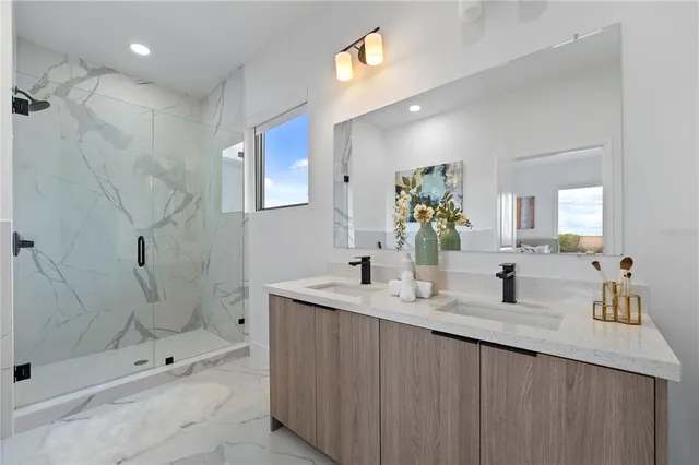 a bathroom with a double vanity sink mirror and shower
