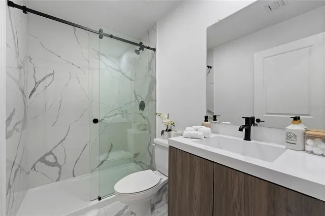 a bathroom with a sink a toilet and shower