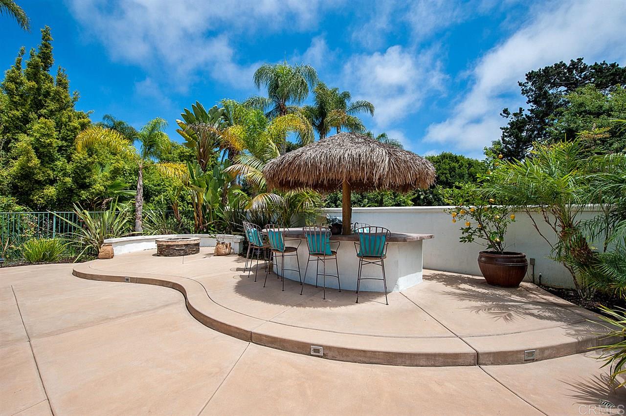 735 Caudor Street Encinitas, CA 92024 - Photo 22 of 25 Outdoor kitchen has built-in BBQ, refrigerator, gas cooktop and bar seating shaded by a palapa.