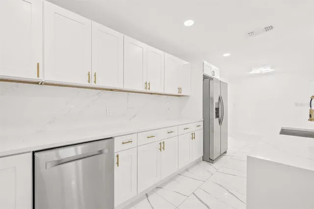 a kitchen with cabinets and a refrigerator