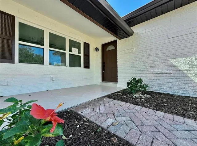 a flower garden is sitting in front of a house