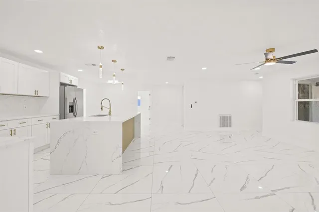 a view of kitchen with center island stainless steel appliances wooden floor and view living room