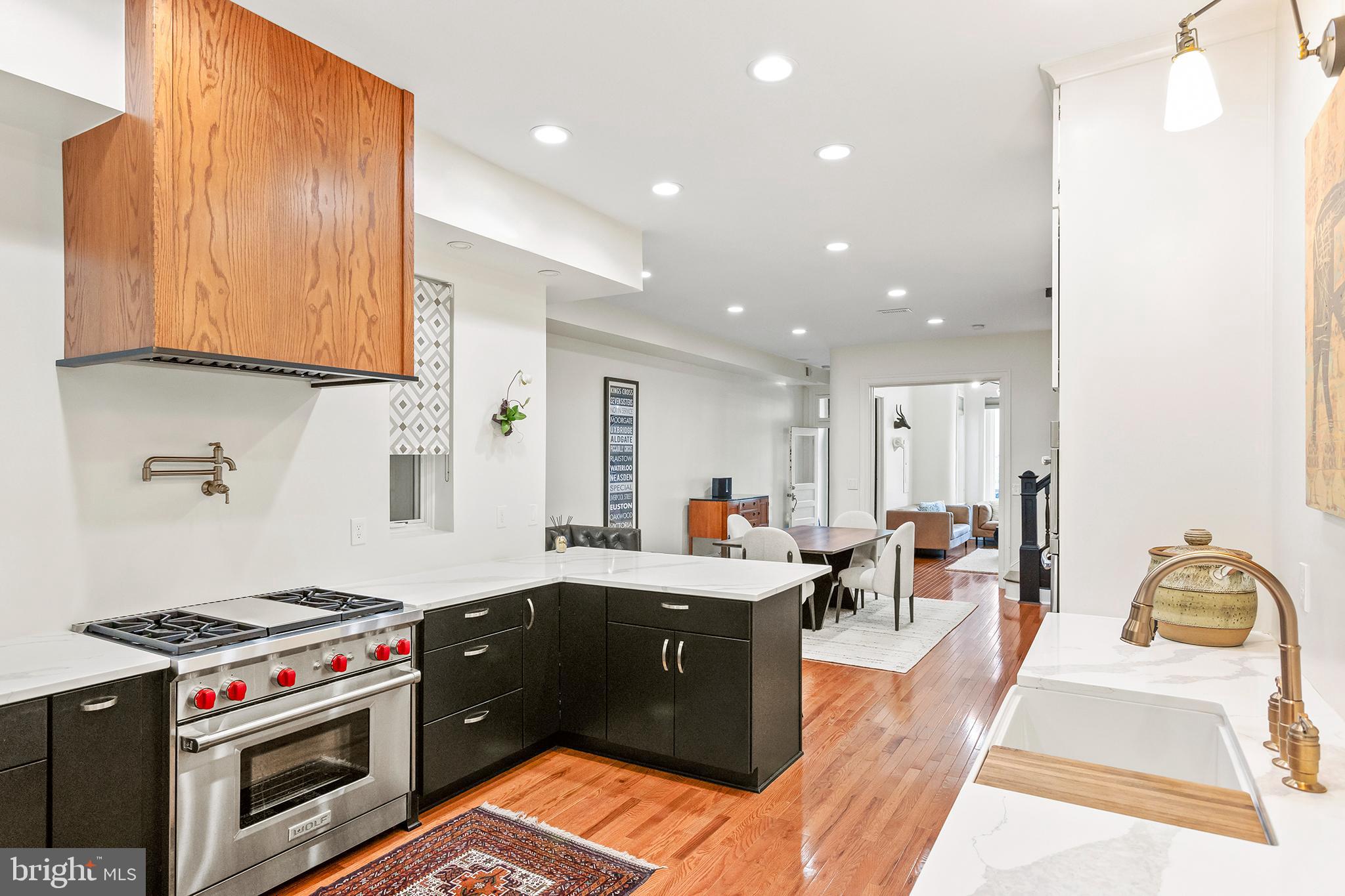 36 Quincy Place Northeast Washington, DC 20002 - Photo 9 of 29 a kitchen with stainless steel appliances granite countertop a stove a sink dishwasher and a dining table with wooden cabinet