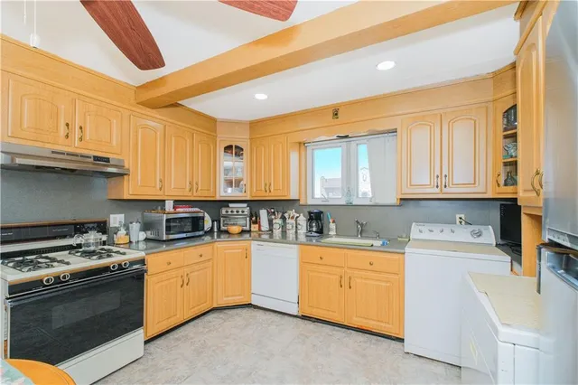 a kitchen with sink a stove and cabinets