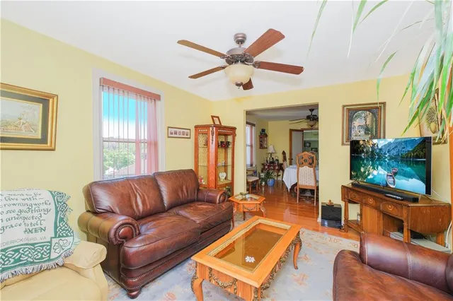 a living room with furniture a ceiling fan and a window