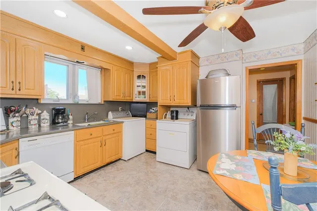a kitchen with sink refrigerator and cabinets