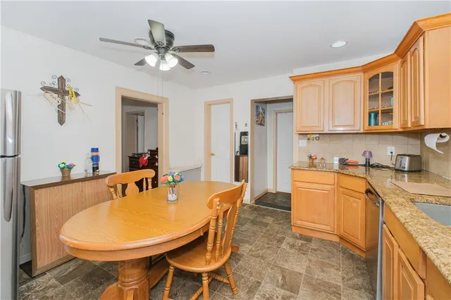 a living room with stainless steel appliances furniture a dining table and a chandelier