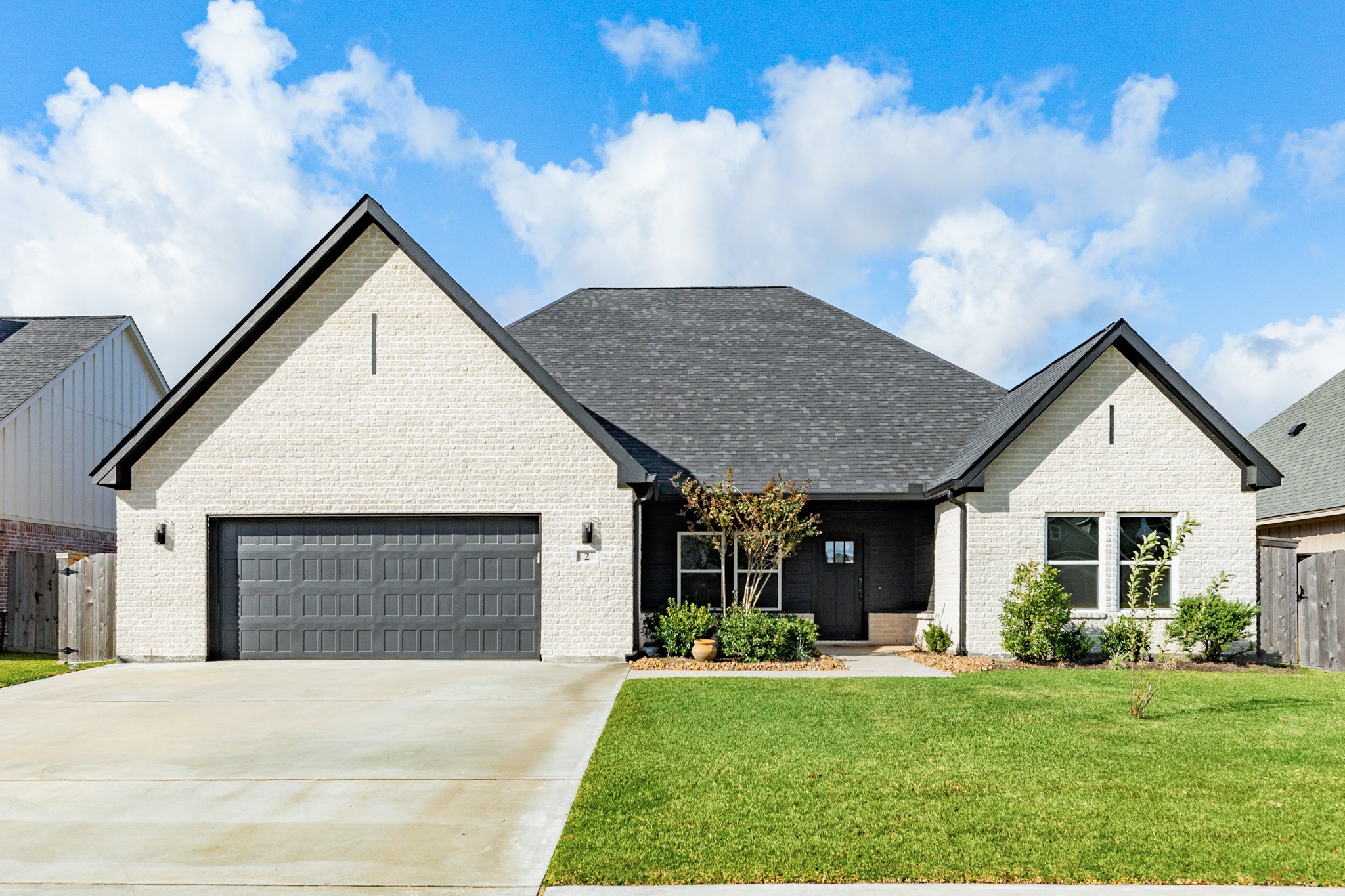 a front view of a house with a yard garden and outdoor seating