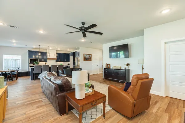 a living room with furniture a flat screen tv and kitchen view