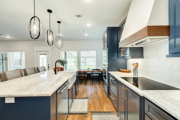 a kitchen with stainless steel appliances granite countertop a sink a stove counter space and living room view