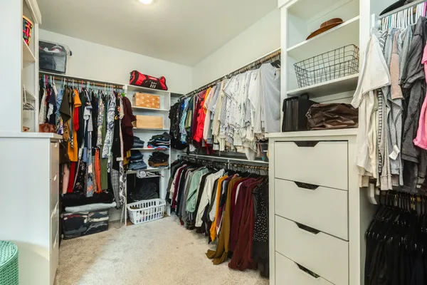 a view of walk in closet with clothes and shoes