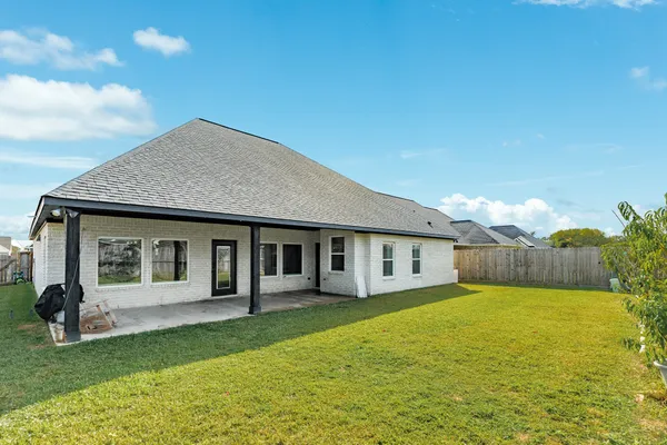 a view of a house with a yard and potted plants