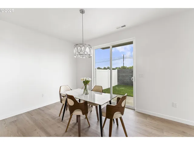 a view of a dining room with furniture a chandelier and wooden floor