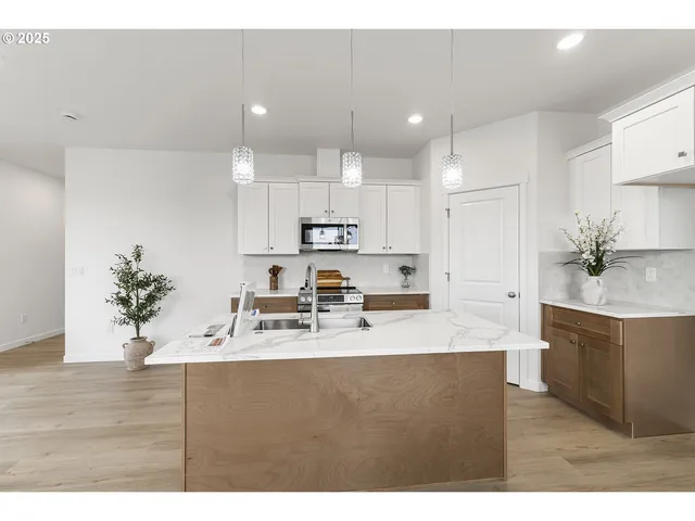 a kitchen with kitchen island white cabinets and stainless steel appliances