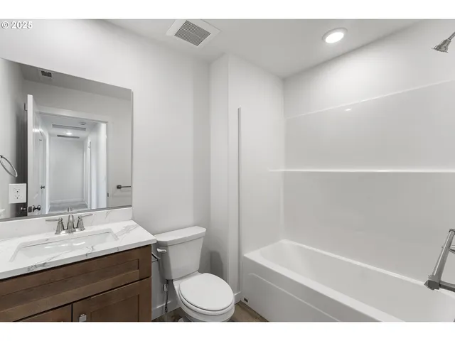 a bathroom with a sink a toilet a mirror and bathtub