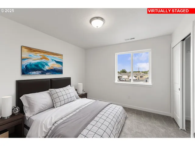 a bedroom with a bed and a painting on the wall