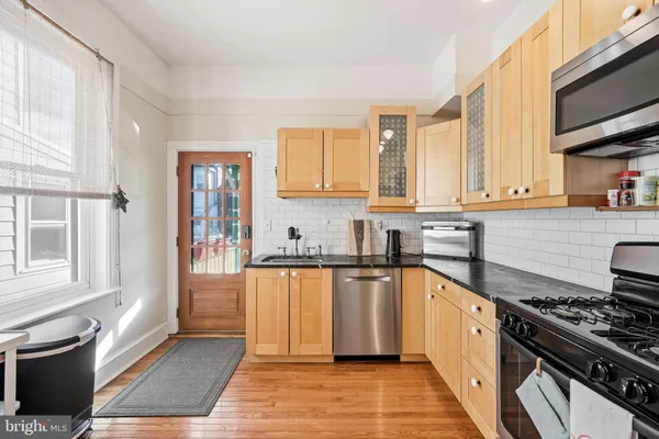 a kitchen with stainless steel appliances granite countertop a stove a sink and a microwave