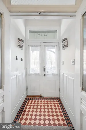 a view of a hallway with wooden floor and a chandelier