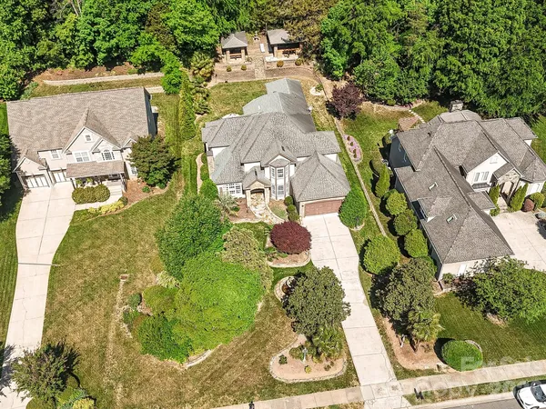 an aerial view of a house with a yard and trees