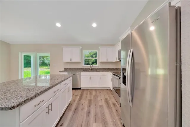 a kitchen with granite countertop a refrigerator and a sink