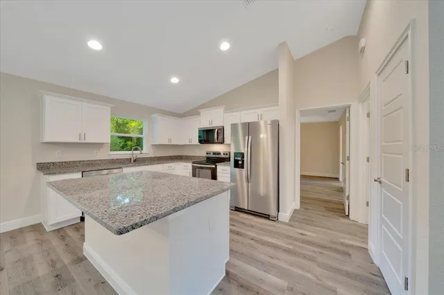 a kitchen with stainless steel appliances granite countertop a refrigerator and a sink