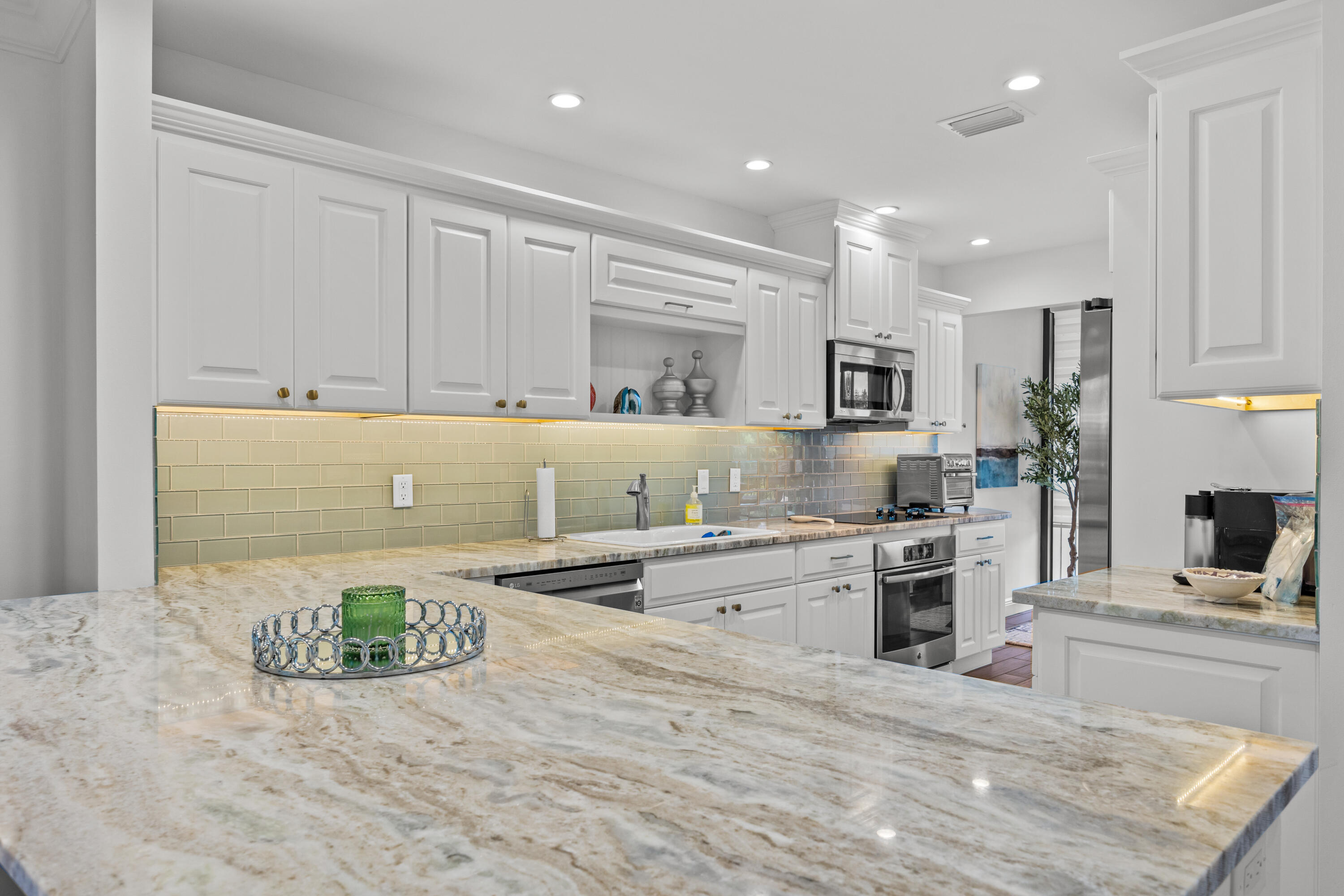 13254 Polo Club Road, Unit C204 Wellington, FL 33414 - Photo 3 of 29 a kitchen with granite countertop a stove top oven sink and cabinets