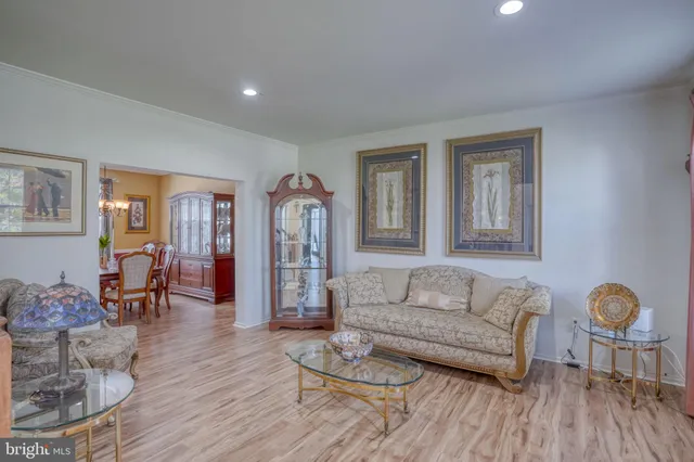 a dining room with furniture a chandelier and wooden floor