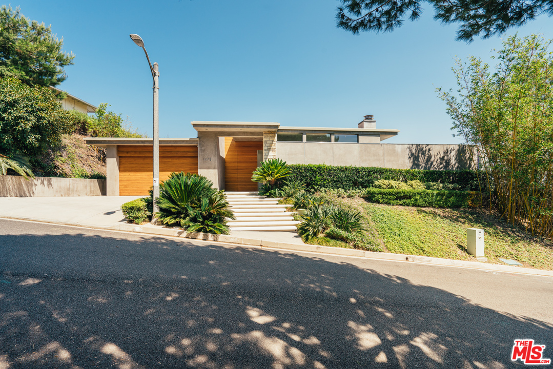 1470 Carla Ridge Beverly Hills, CA 90210 - Photo 2 of 44 a front view of a house with a yard and potted plants