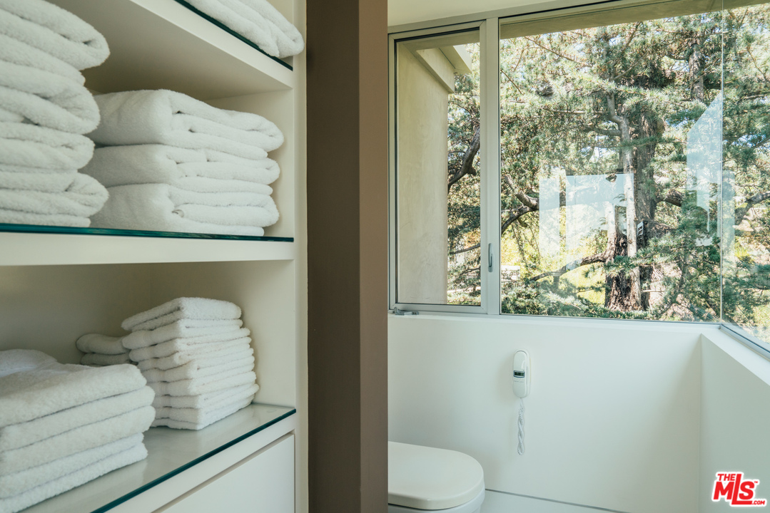 1470 Carla Ridge Beverly Hills, CA 90210 - Photo 20 of 44 a bathroom with a toilet and a shower curtain