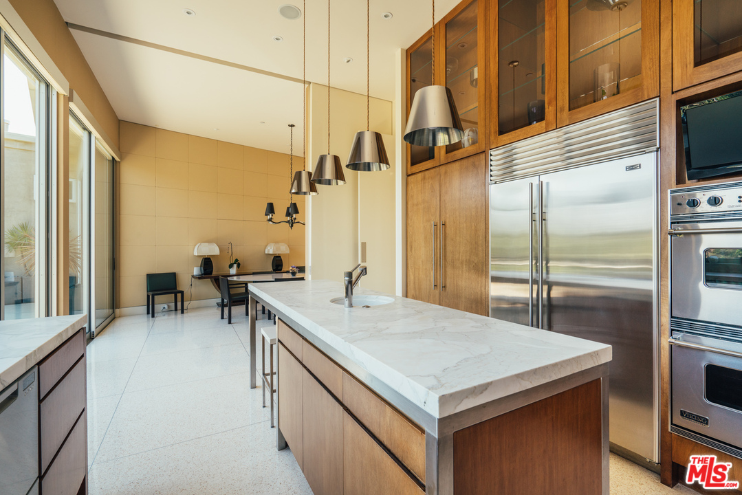 1470 Carla Ridge Beverly Hills, CA 90210 - Photo 25 of 44 a kitchen with a sink a counter appliances and cabinets