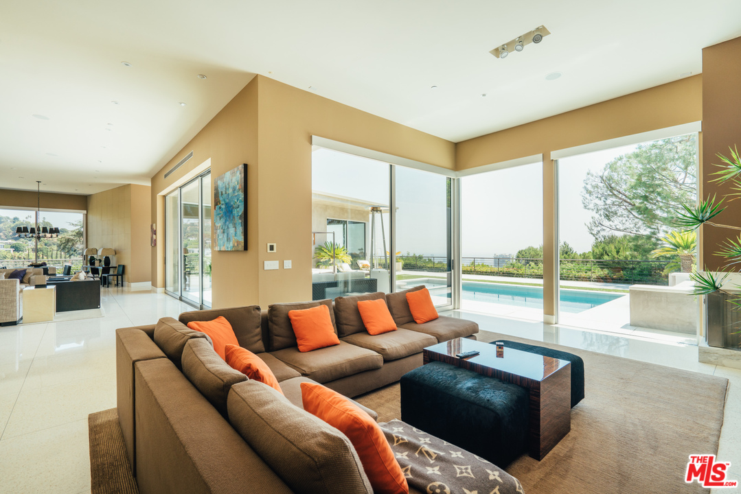 1470 Carla Ridge Beverly Hills, CA 90210 - Photo 30 of 44 a living room with furniture and a floor to ceiling window