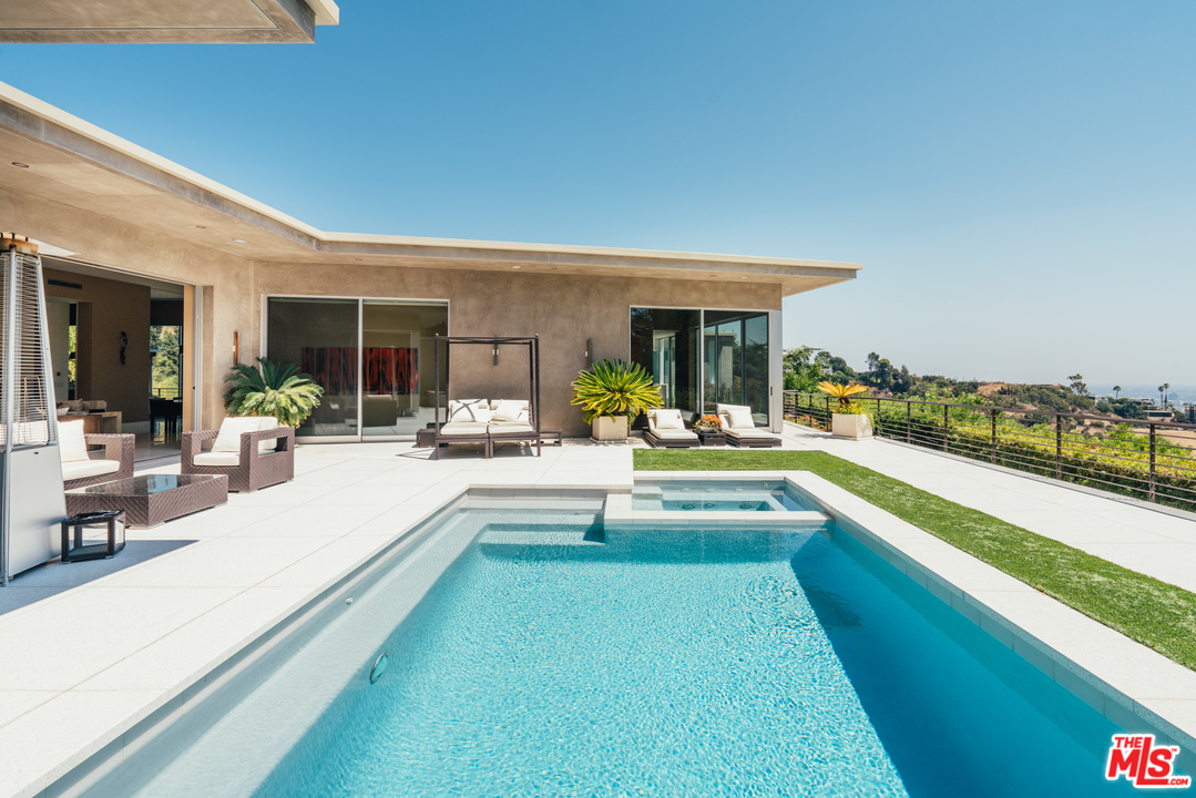 1470 Carla Ridge Beverly Hills, CA 90210 - Photo 37 of 44 a view of swimming pool with outdoor seating and a garden