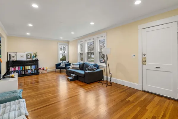 a living room with furniture and a wooden floor