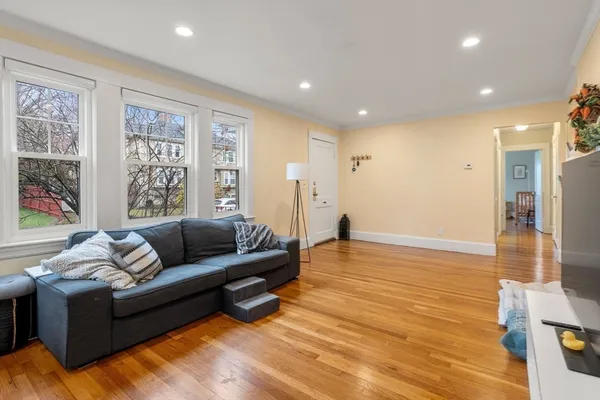 a living room with furniture and a hard wood floor