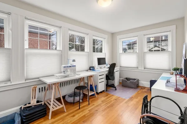 a view of a workspace with furniture window and wooden floor