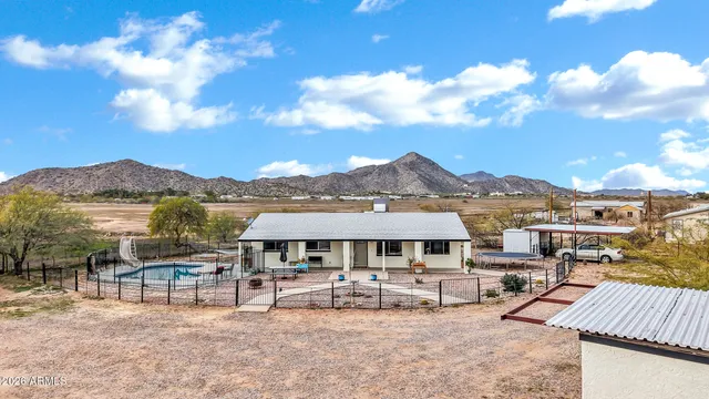 a view of a house with wooden deck and furniture