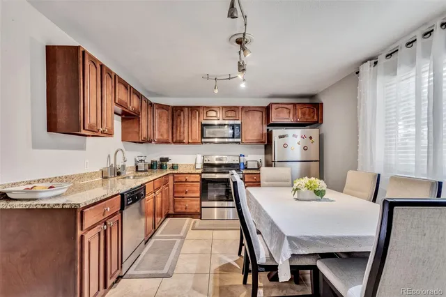 a kitchen with stainless steel appliances granite countertop a stove a sink and a refrigerator