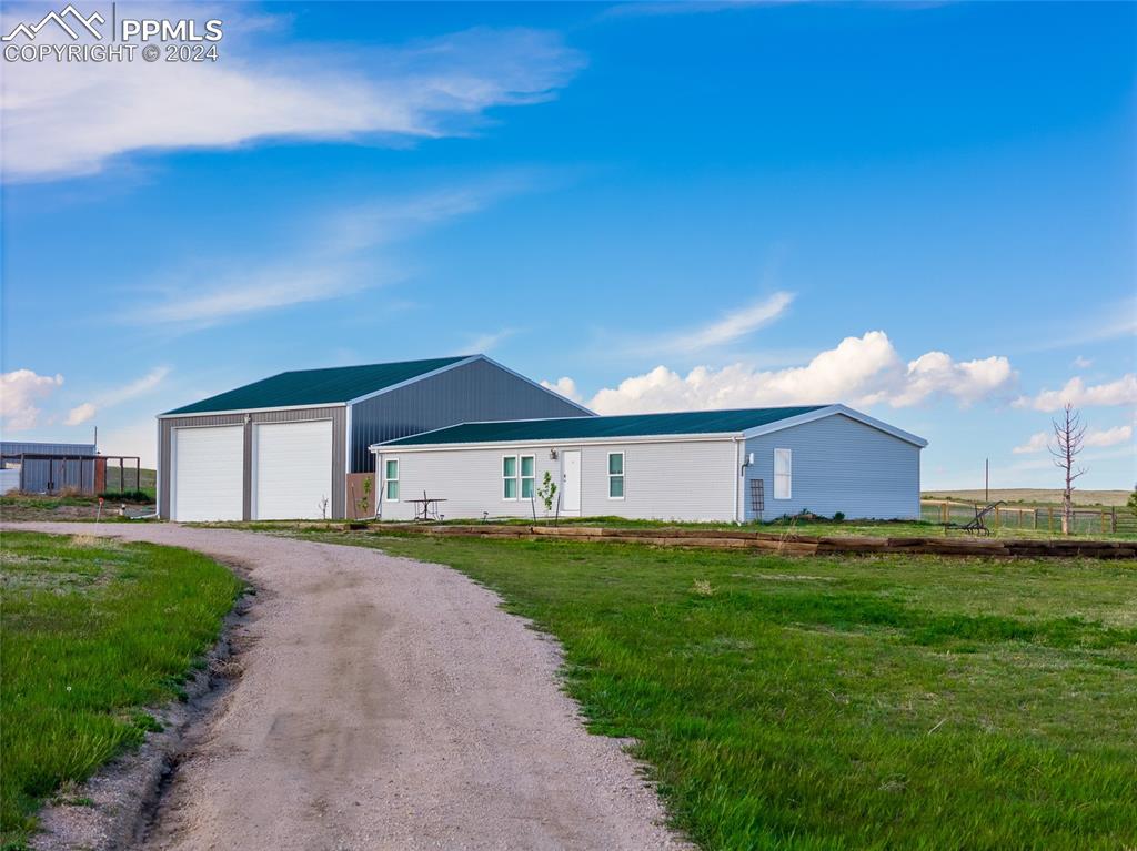 Home with a garage, a front yard, workshop/barn/RV garage