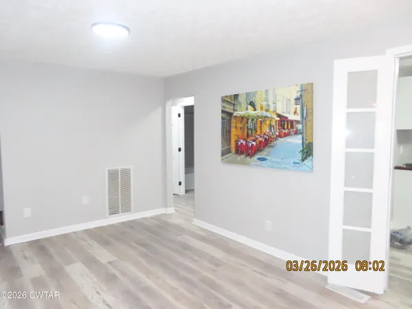 a view of a room with wooden floor and wall painting