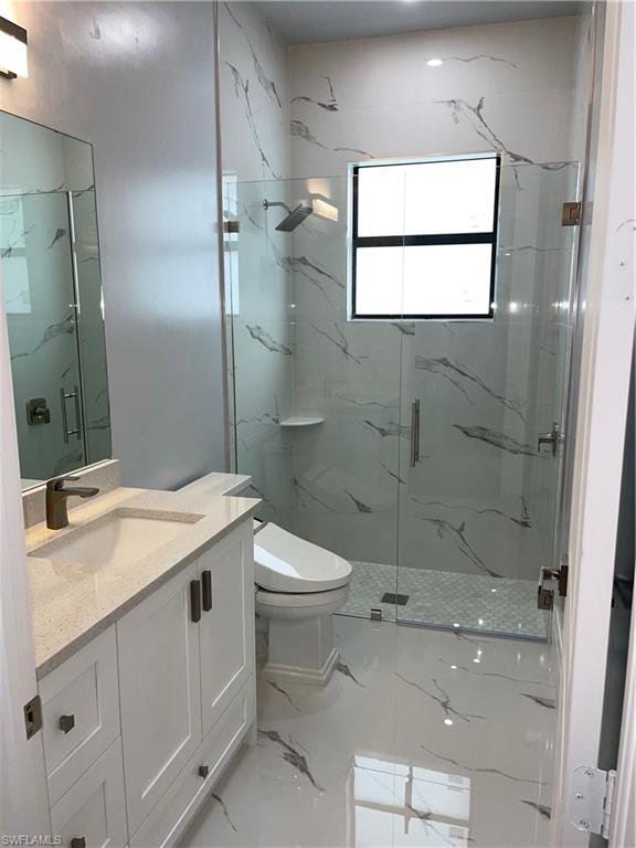 3203 68th Street Southwest Naples, FL 34105 - Photo 28 of 34 a bathroom with a granite countertop sink toilet and shower