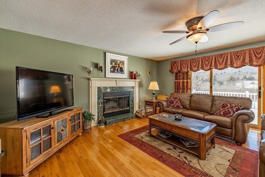 158 Scantic Road Hampden, MA 01036 - Photo 13 of 42 a living room with furniture a flat screen tv and a fireplace