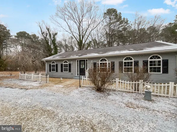 a front view of a house with a yard covered in snow