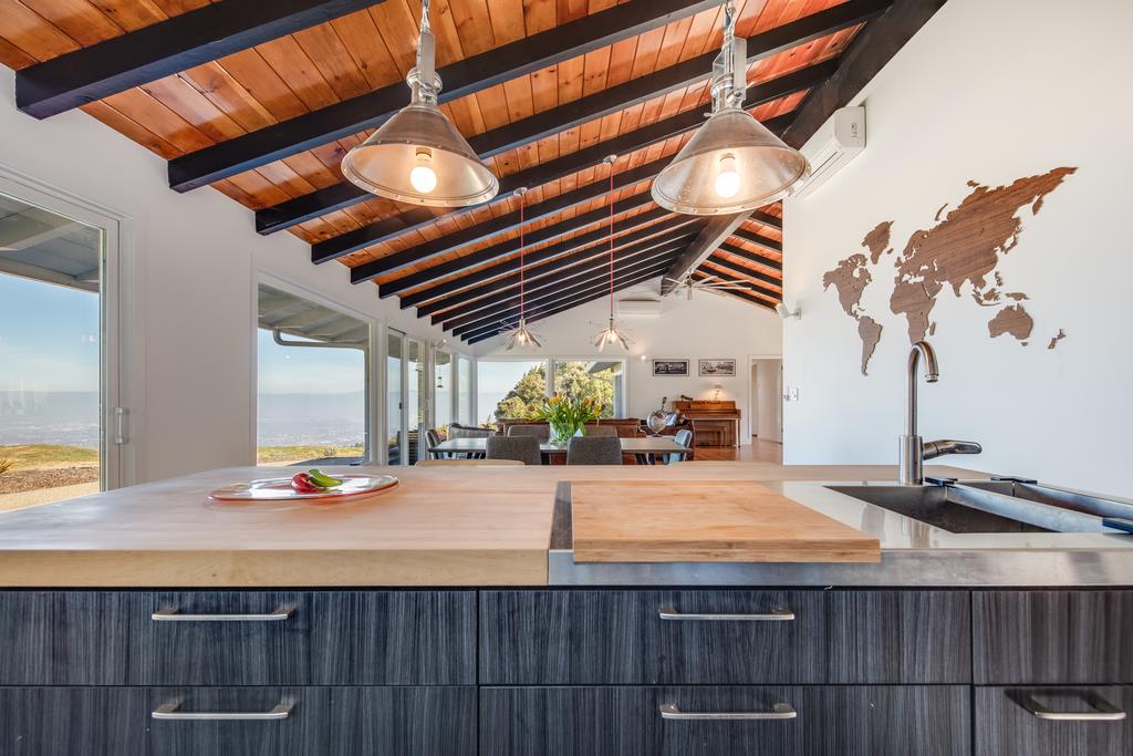 16984 Bohlman Road Saratoga, CA 95070 - Photo 21 of 50 a room with kitchen island a chandelier and wooden cabinets