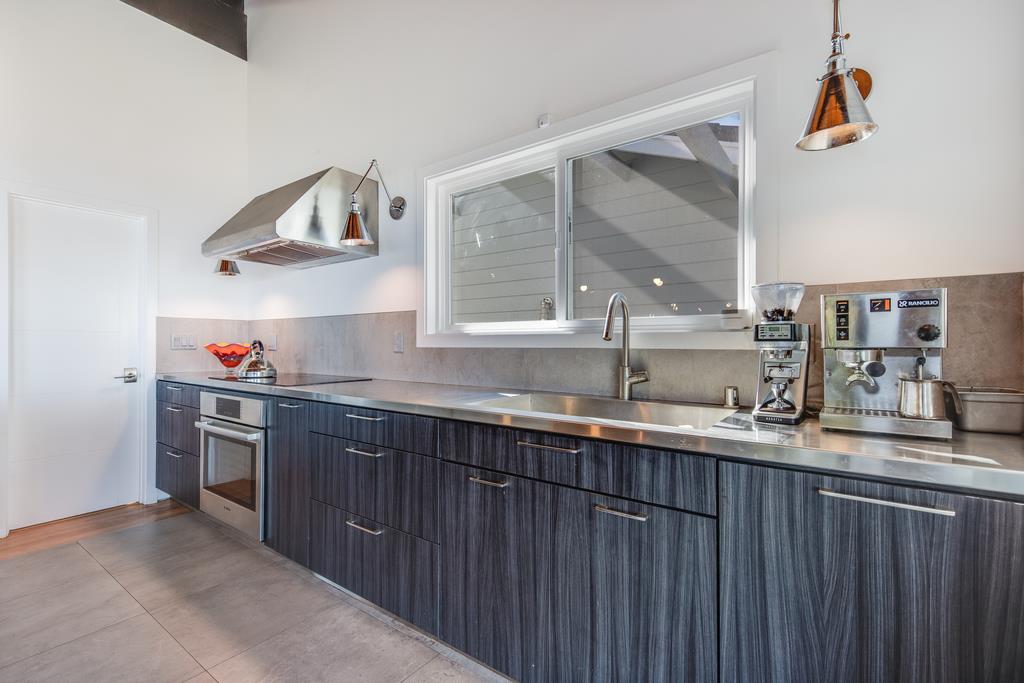 16984 Bohlman Road Saratoga, CA 95070 - Photo 22 of 50 a kitchen with stainless steel appliances granite countertop a sink and wooden cabinets