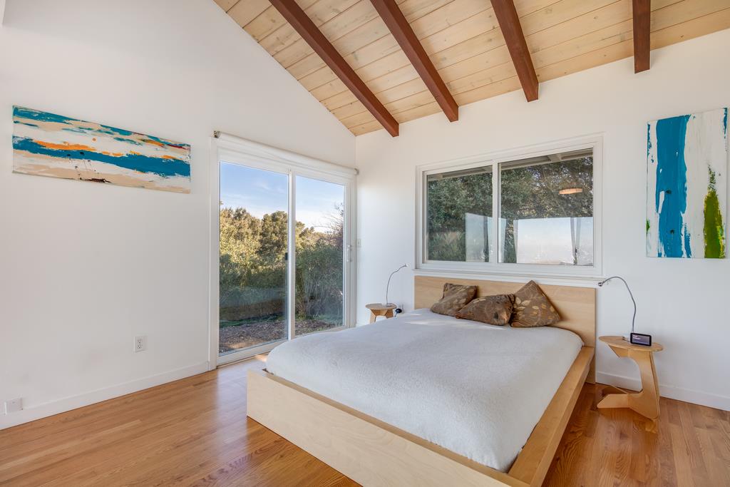 16984 Bohlman Road Saratoga, CA 95070 - Photo 38 of 50 a bedroom with a bed and a large window with outer view