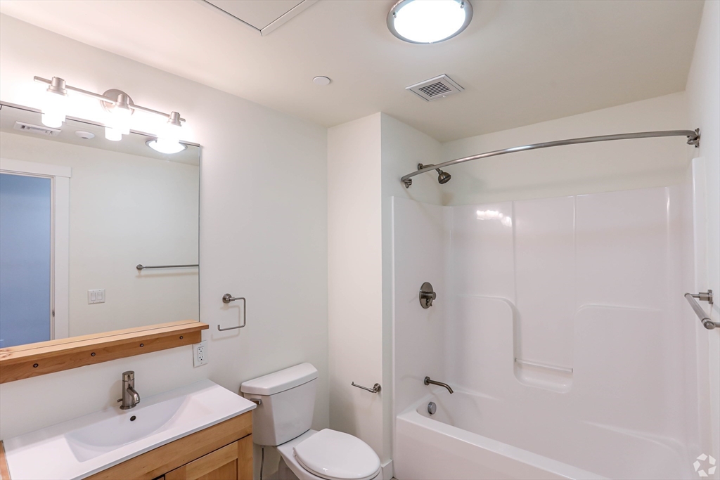 87 New Street, Unit 306 Cambridge, MA 02138 - Photo 6 of 11 a bathroom with a bathtub shower sink vanity and toilet