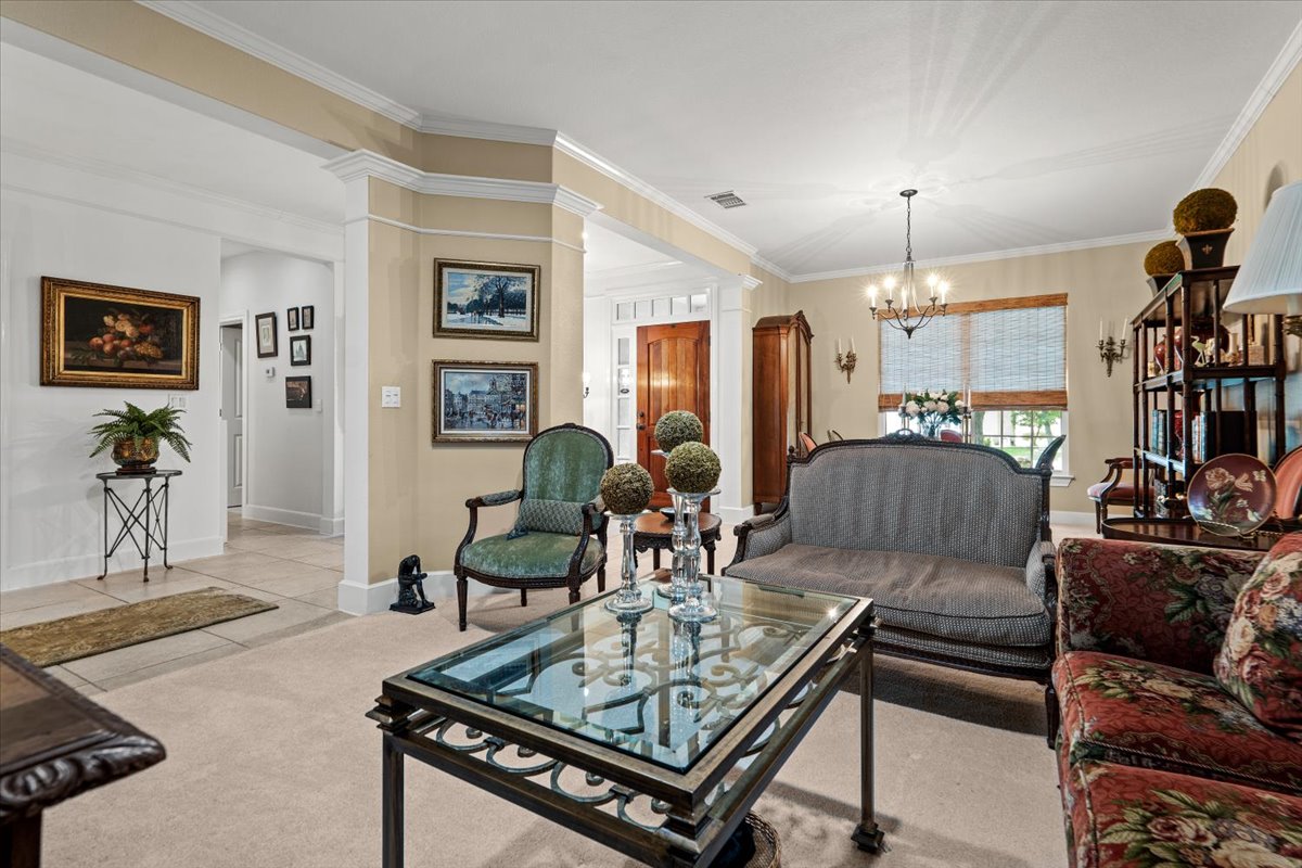503 Breezeway Lane Georgetown, TX 78633 - Photo 24 of 38 Comfortable living space with crown molding and a natural flow into the dining area, offering flexibility for both formal and casual use.