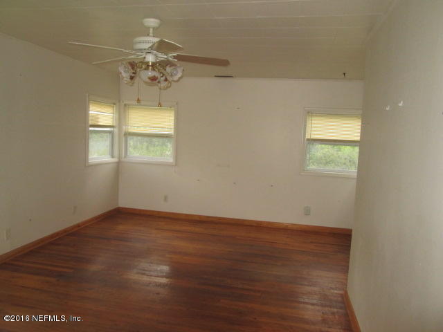 6252 Firestone Road Jacksonville, FL 32244 - Photo 2 of 12 wooden floor in an empty room with a window