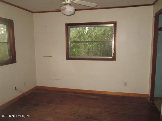 6252 Firestone Road Jacksonville, FL 32244 - Photo 7 of 12 an empty room with wooden floor and windows
